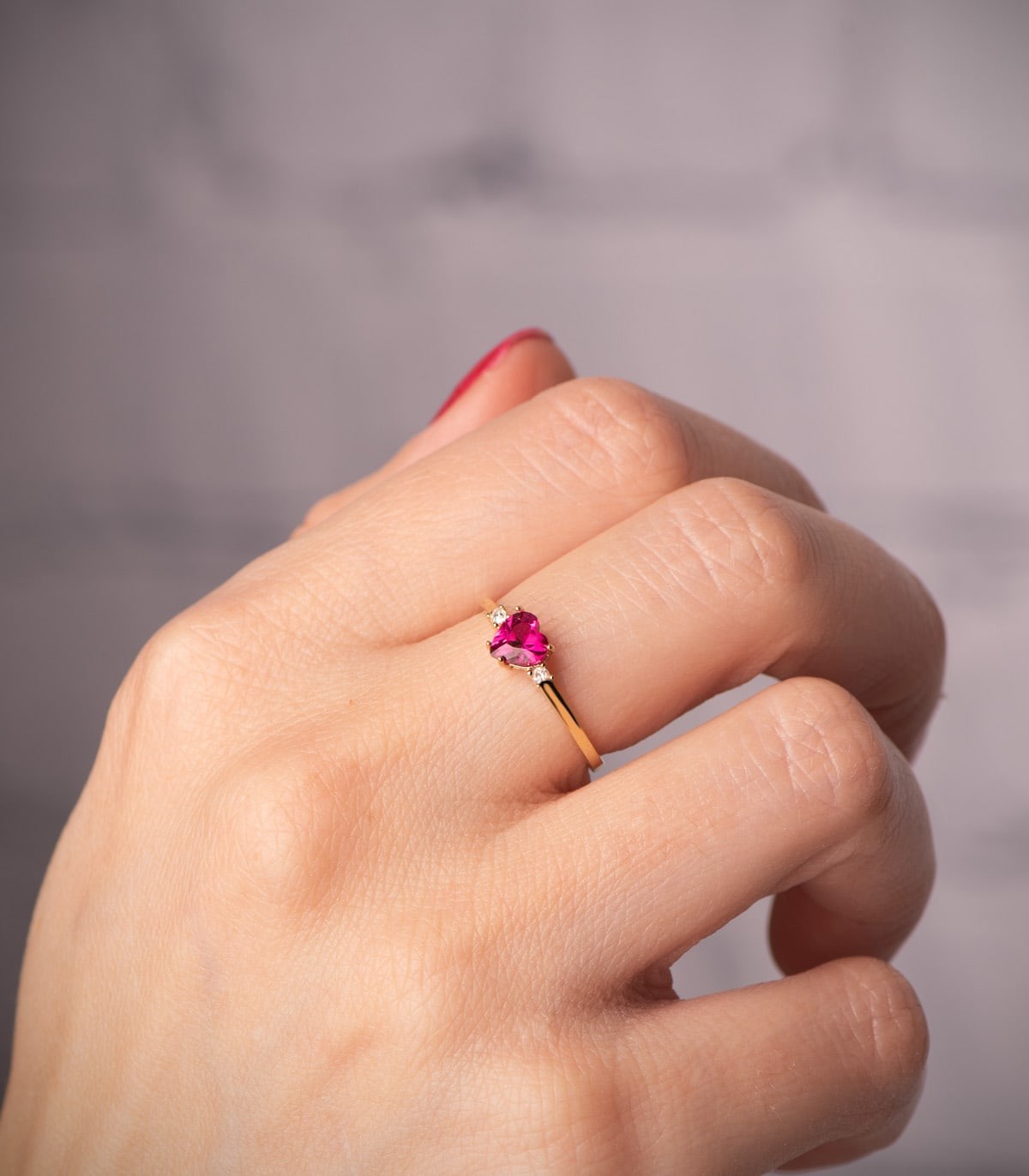 Bague en or jaune 18K avec un cœur rouge, symbole d’amour et promesse.