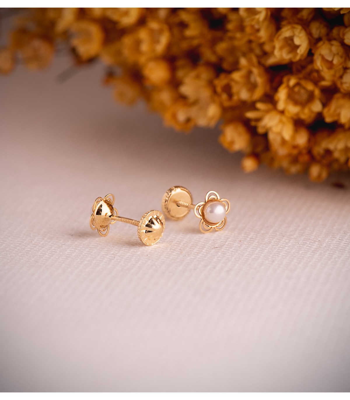 Orecchini con perle per bambina in oro 18 kt Odina, forma a fiore traforato e chiusura a vite.